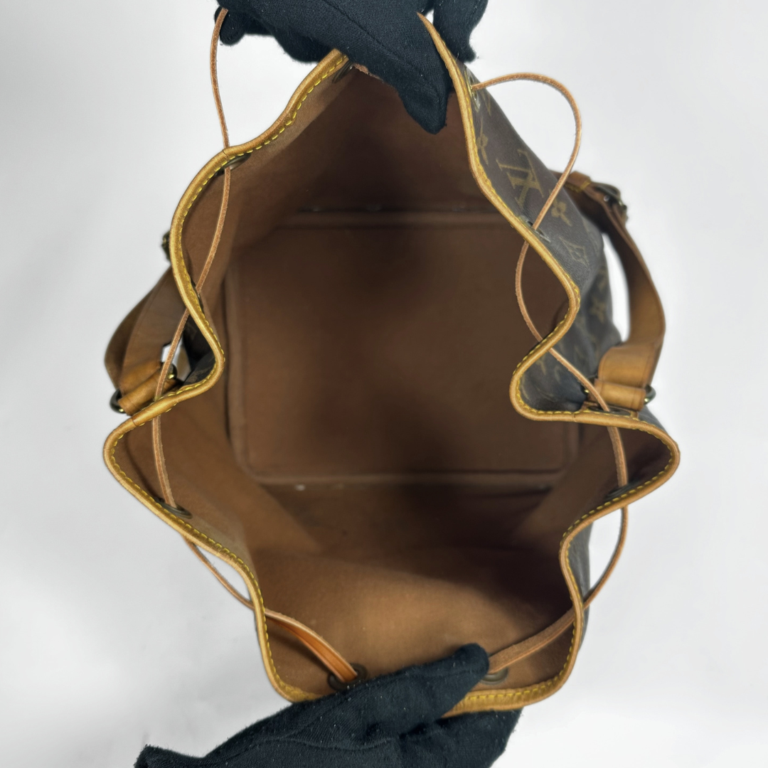 Brown leather bag with gold trim on a white background