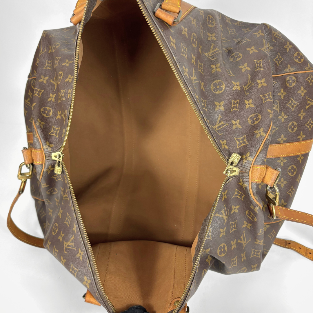 Brown Louis Vuitton travel bag with monogram pattern on a white background