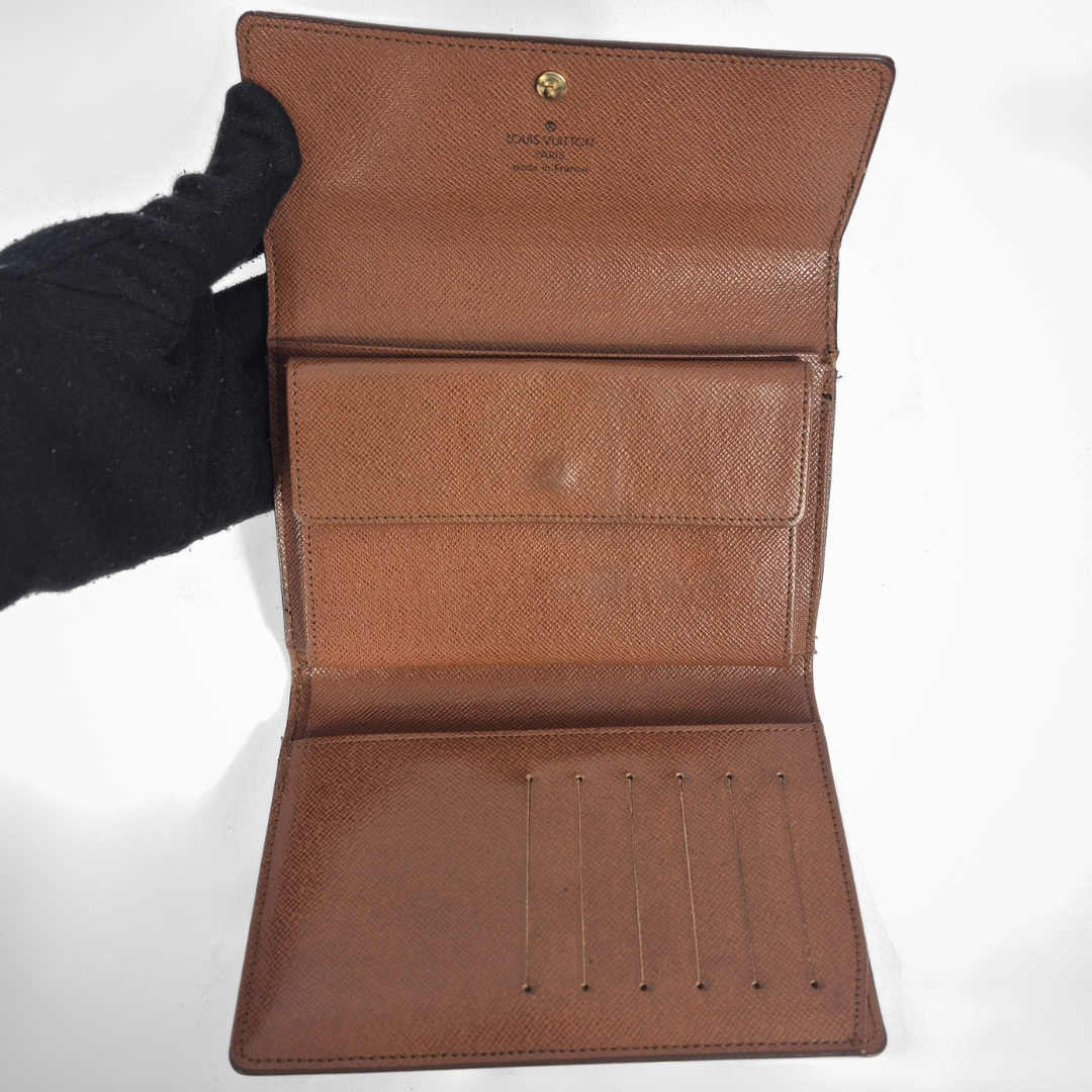 Louis Vuitton wallet with monogram pattern on a white background
