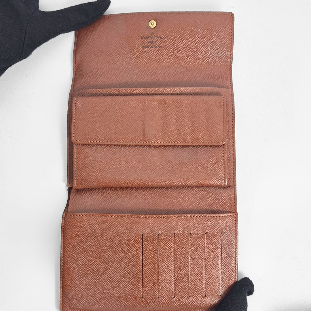 Brown leather wallet with visible brand name on a white background