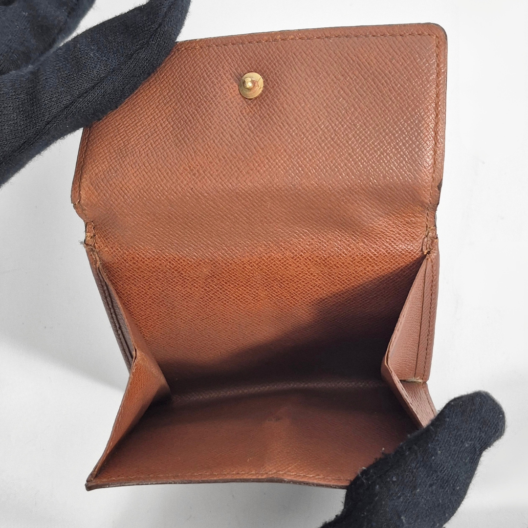 Brown leather wallet with gold button on a light gray background