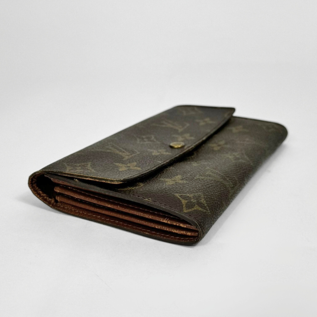 Brown wallet with gold monogram pattern on a white background