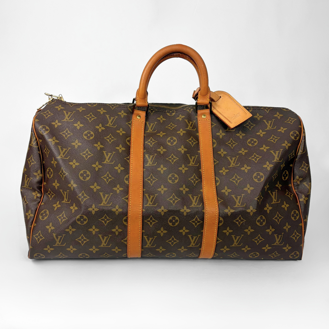 Brown hand bag with orange accents and a prominent logo pattern on a white background