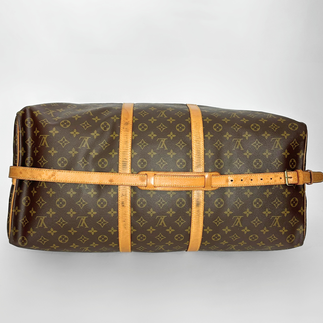 Louis Vuitton monogram duffel bag with brown leather straps on a light gray background