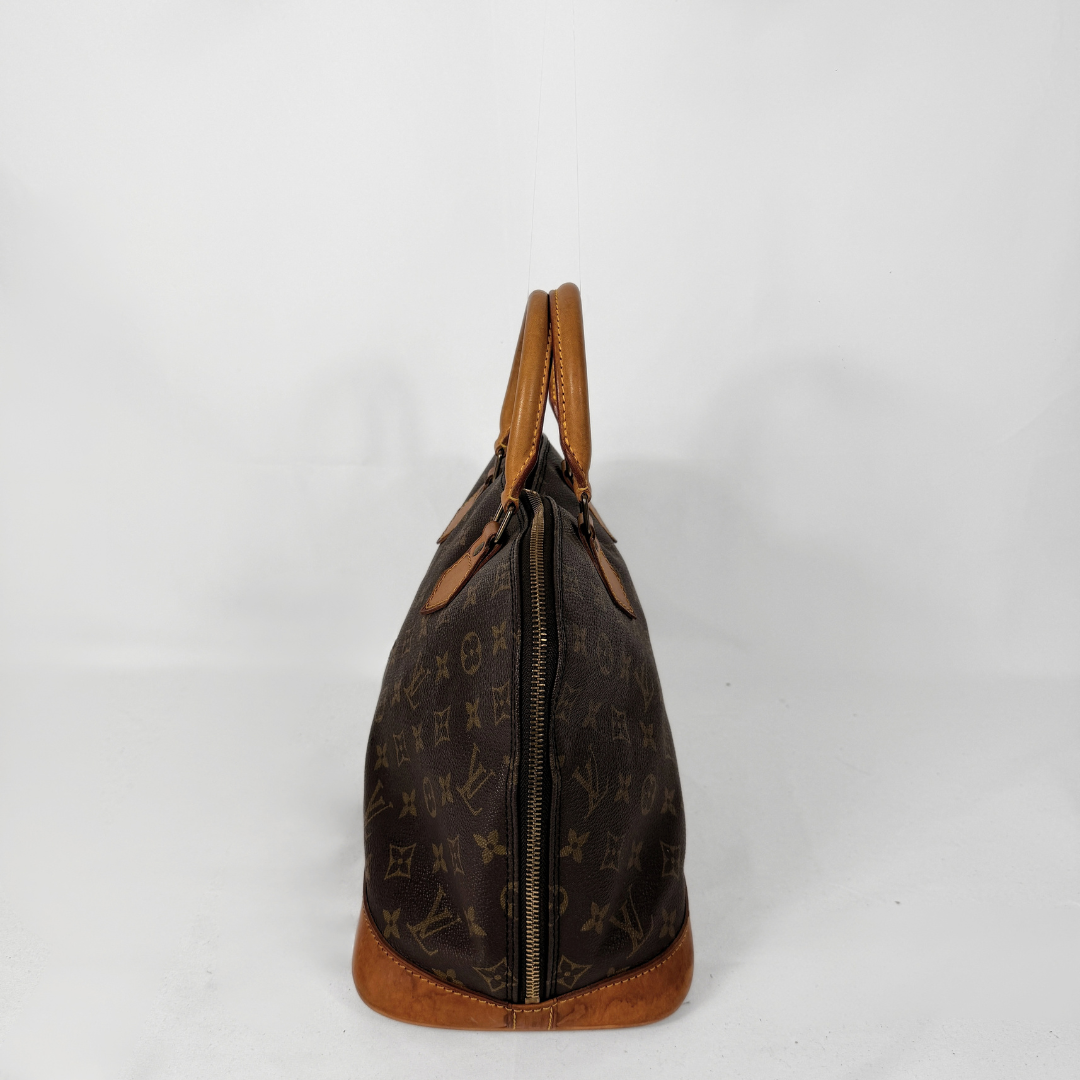 Louis Vuitton monogram canvas bag in dark brown with tan leather trim and handles, shown from the side against a white background.