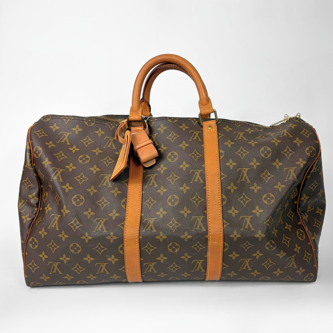 Brown hand bag with orange accents and a prominent logo pattern on a white background