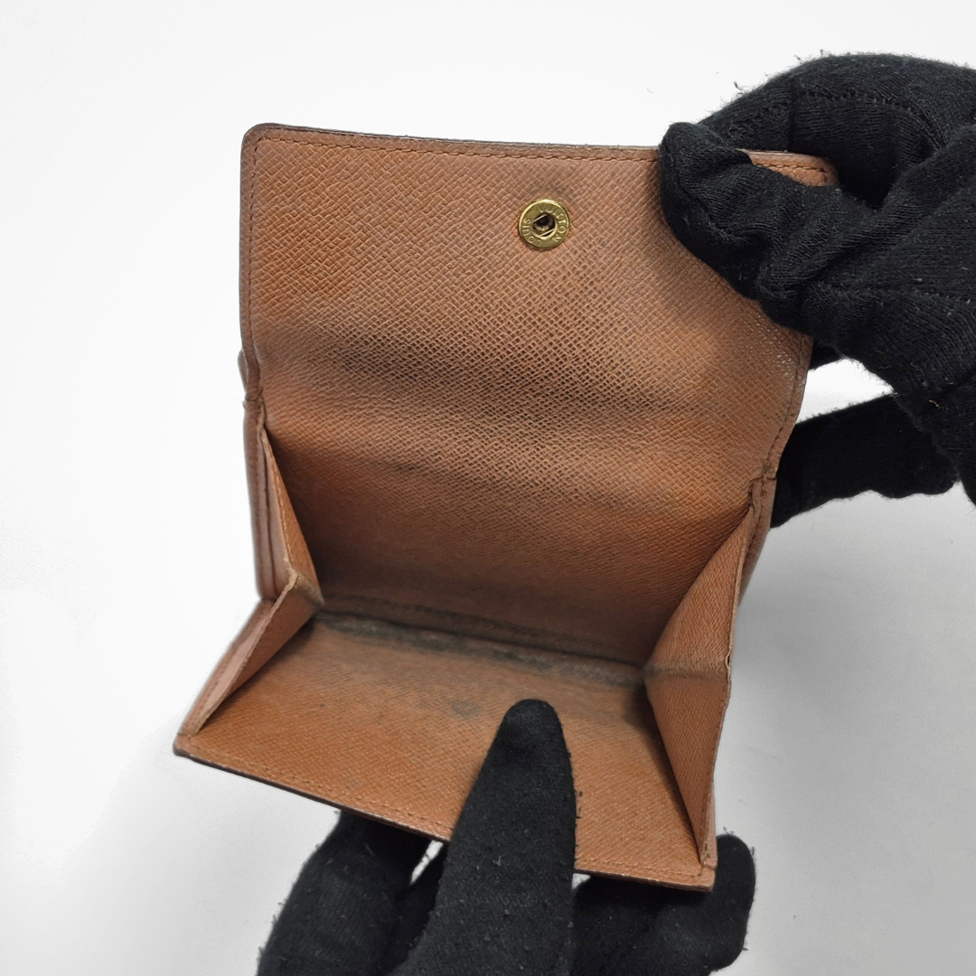 Brown wallet with monogram pattern on a light gray background