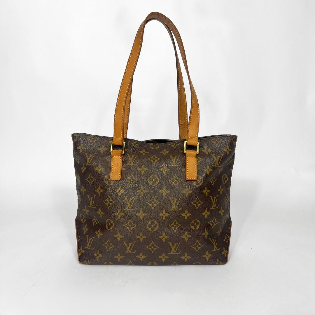 Brown monogram handbag with tan handles on a white background