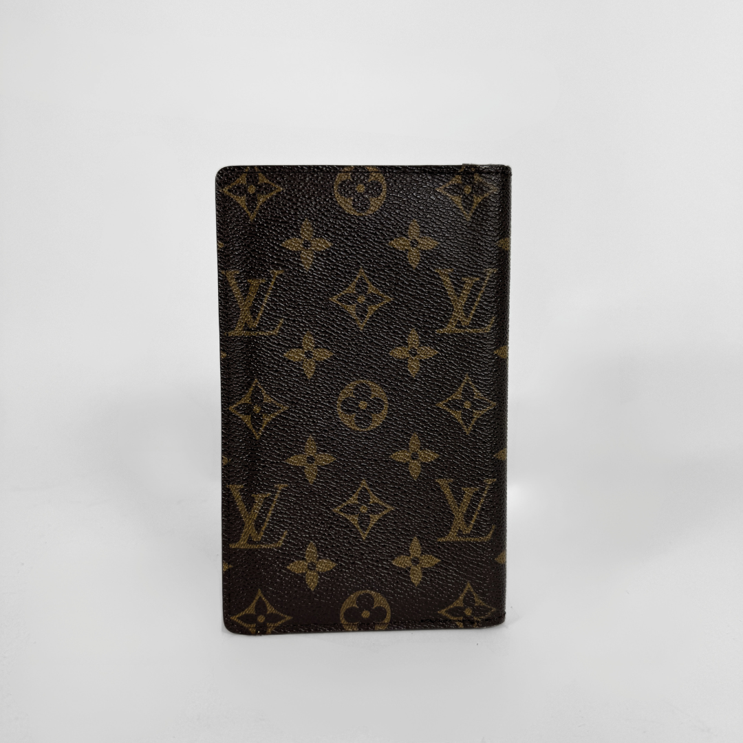 A Louis Vuitton monogram card holder or passport cover made of dark brown coated canvas with the classic tan/gold LV monogram pattern, standing upright on a light gray background.
