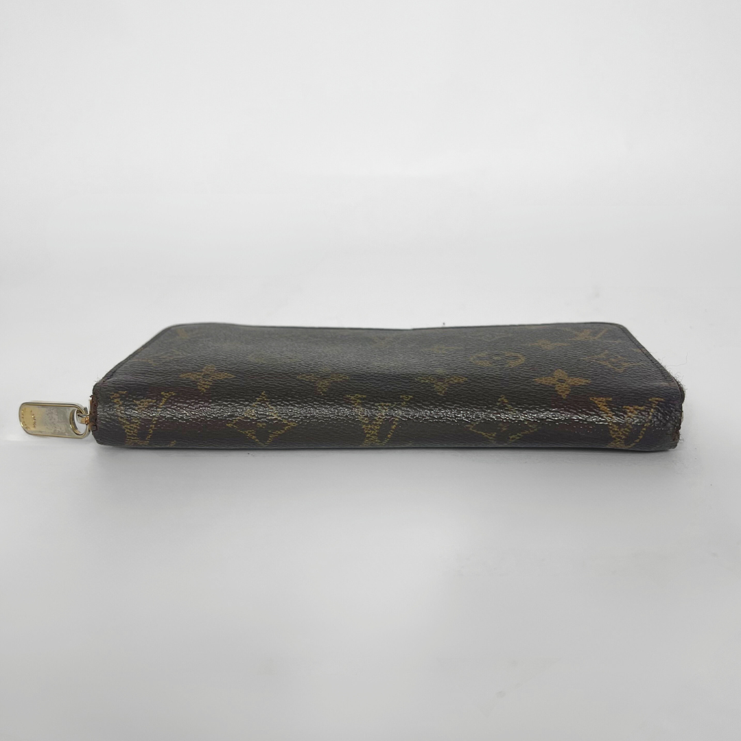 Louis Vuitton wallet with monogram pattern on a white background