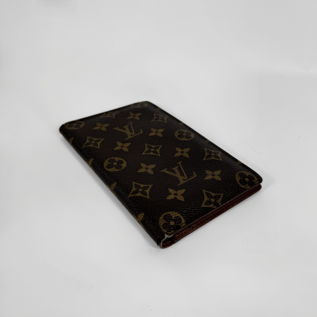 A Louis Vuitton monogram canvas card holder or wallet in dark brown with tan monogram motifs, shown on a plain white background.