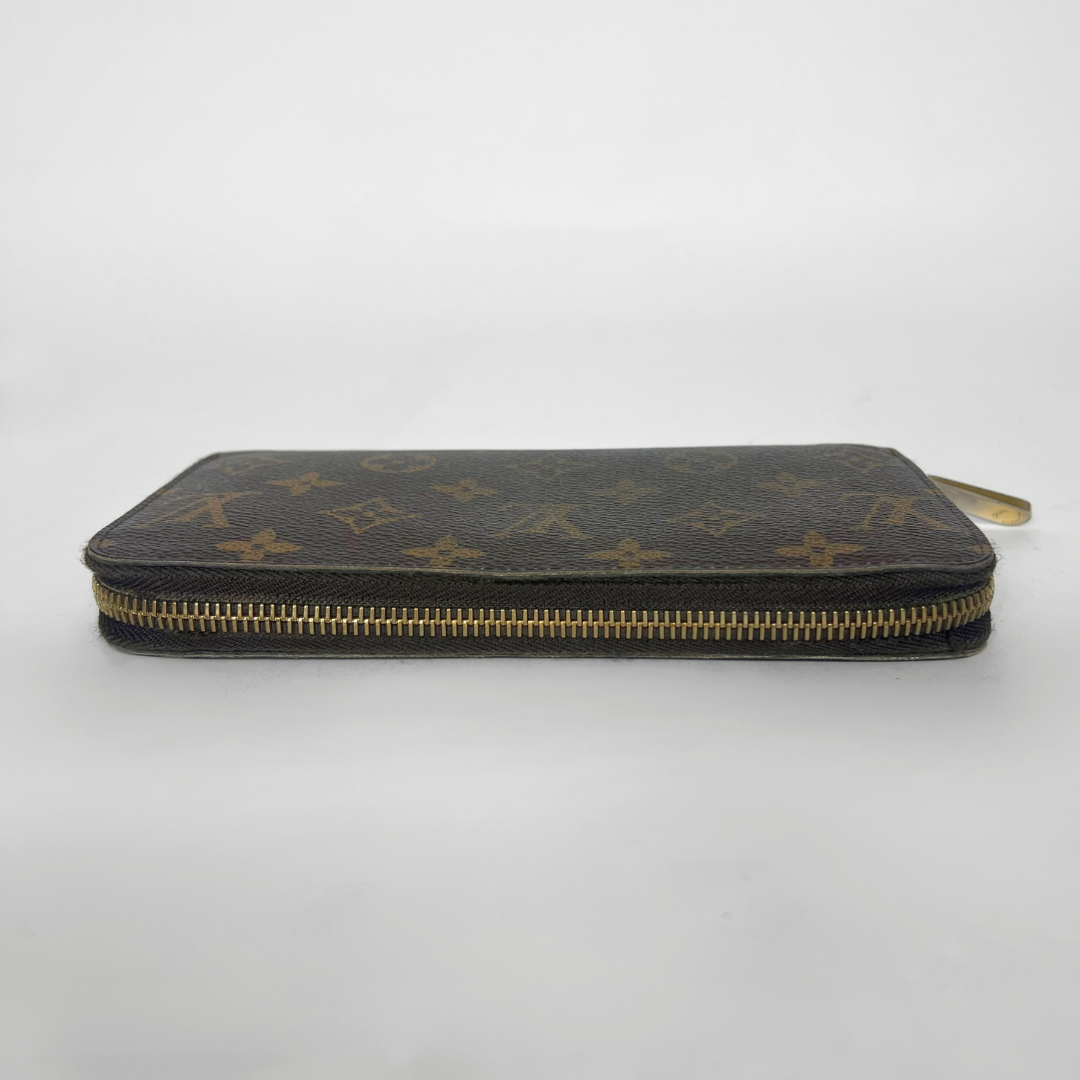 Louis Vuitton wallet with monogram pattern on a white background
