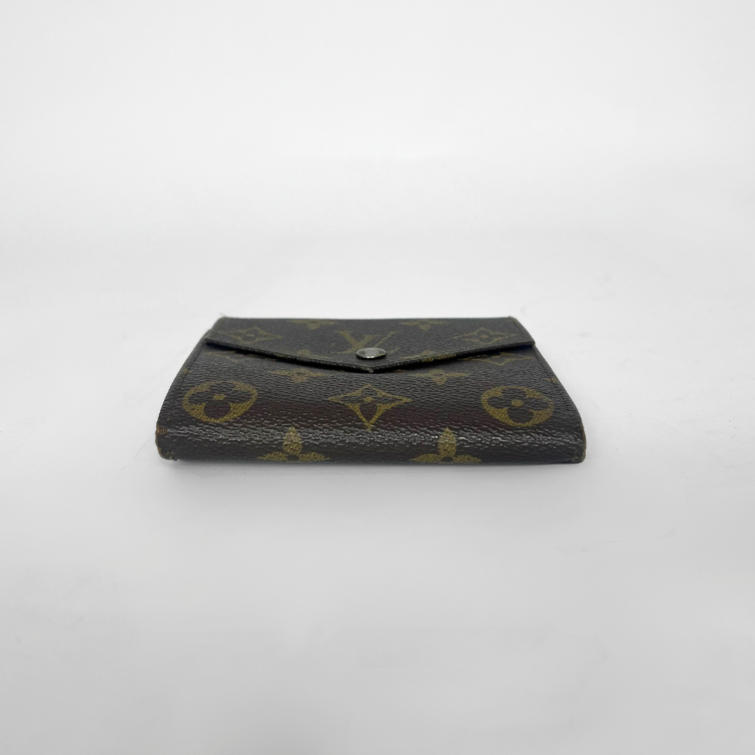 Louis Vuitton wallet with monogram pattern on a white background