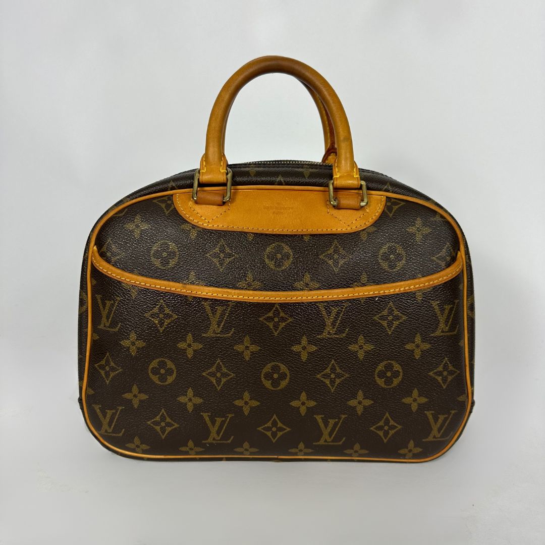 Louis Vuitton monogram canvas handbag with tan leather handles and trim, photographed against a plain light background.