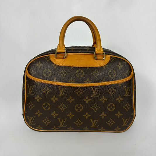 Louis Vuitton monogram canvas handbag with tan leather handles and trim, photographed against a plain light background.