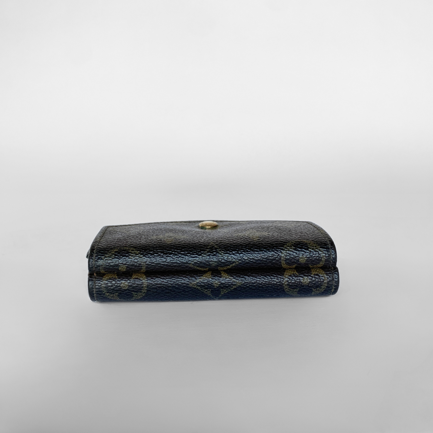 Louis Vuitton wallet with monogram pattern on a light gray background