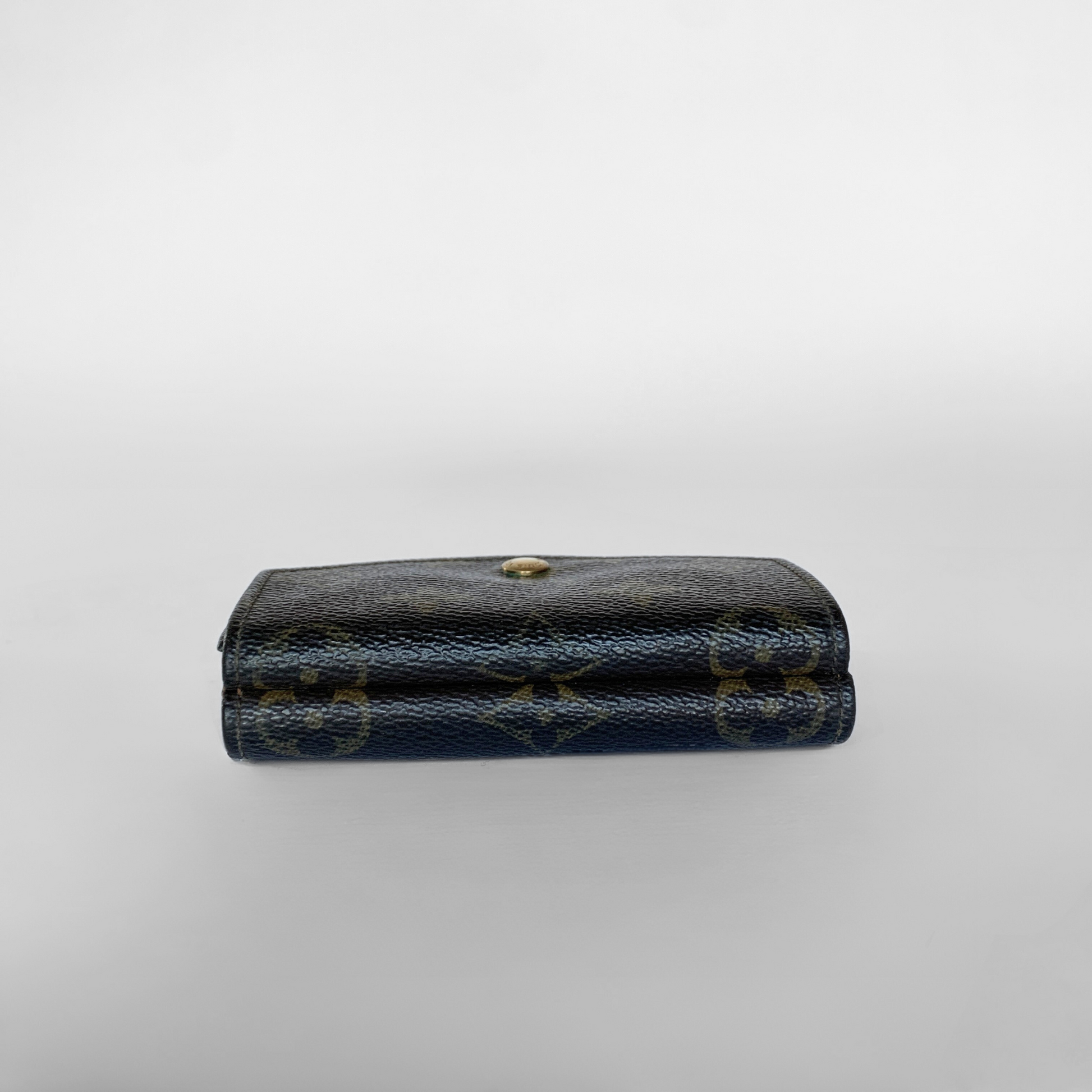 Louis Vuitton wallet with monogram pattern on a light gray background