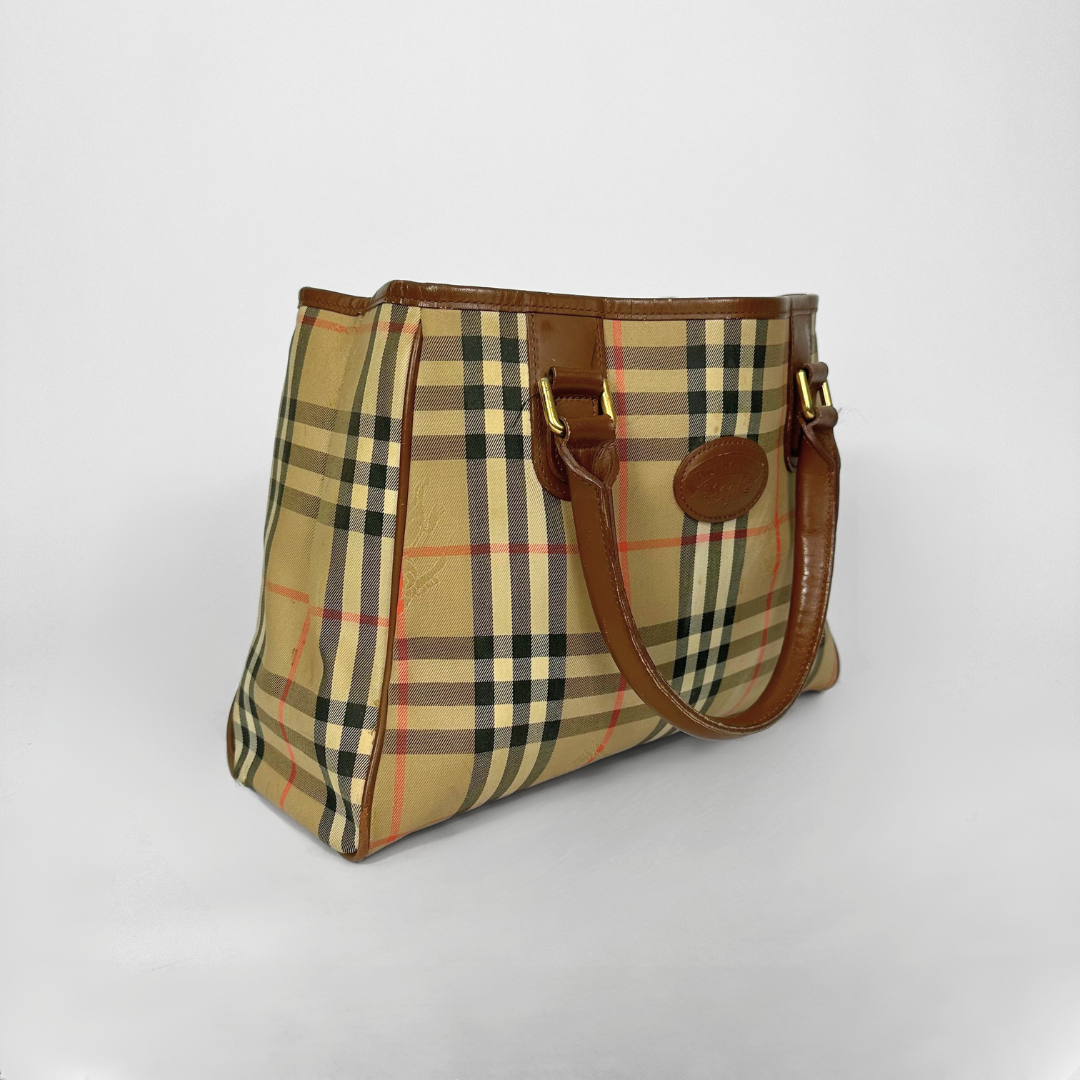Plaid handbag with brown leather accents on a light gray background