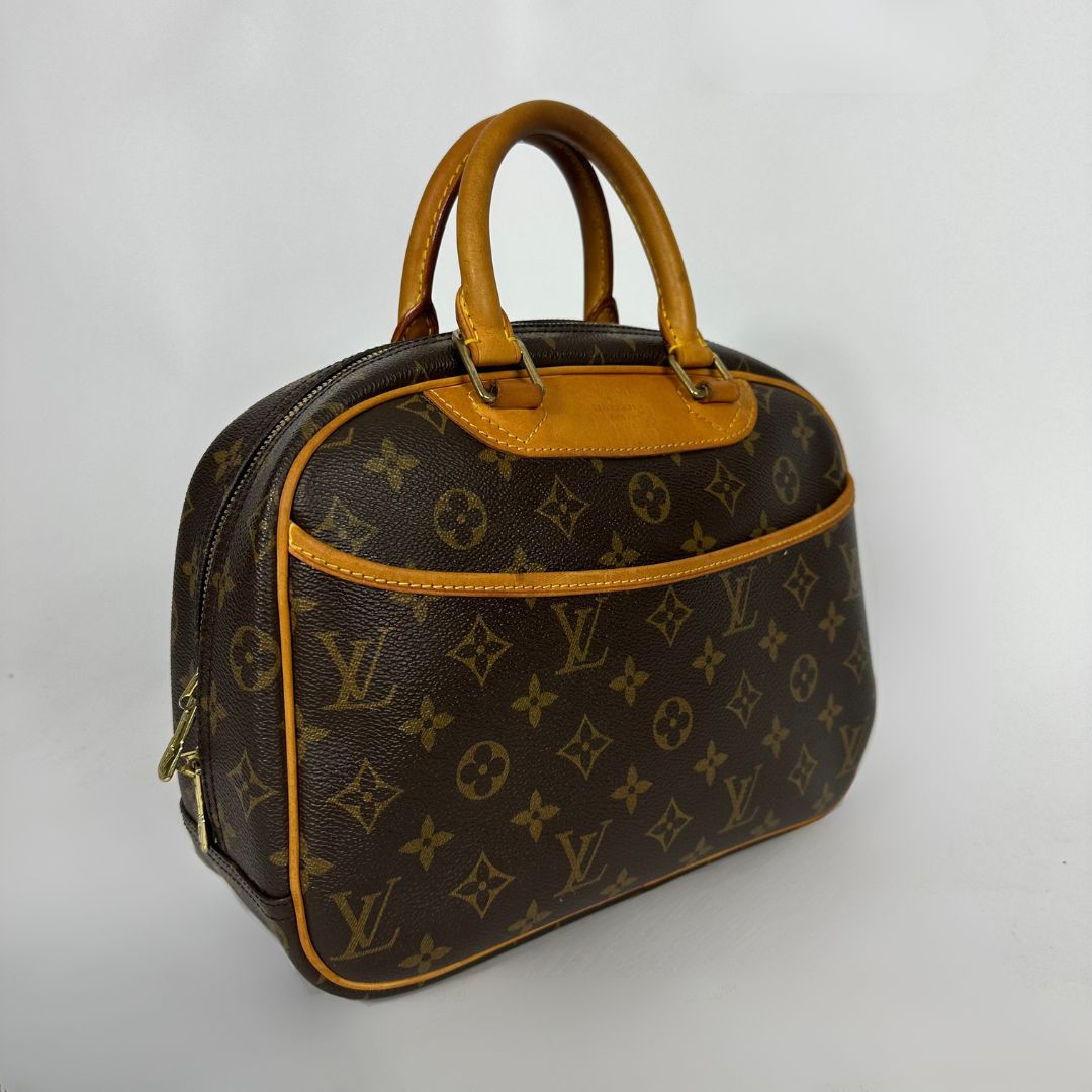 Louis Vuitton monogram canvas handbag with tan leather handles and trim, photographed on a plain light background.