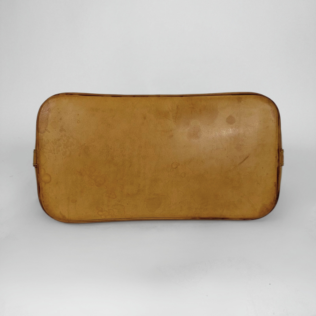 A vintage tan leather cosmetic pouch or case with rounded corners and a zippered closure, shown against a plain light gray background.