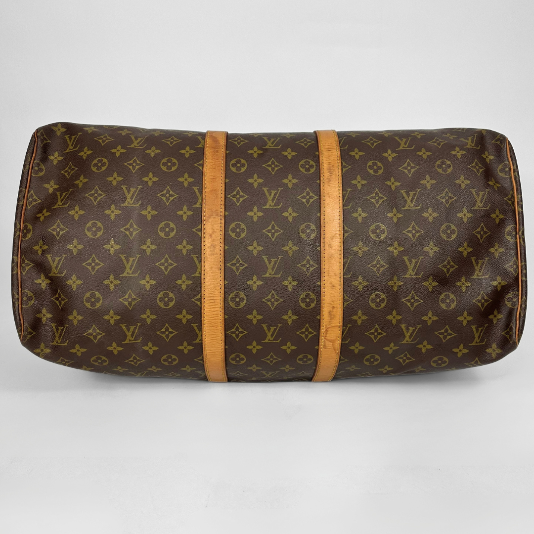 Brown monogram patterned bag with wooden accents on a white background