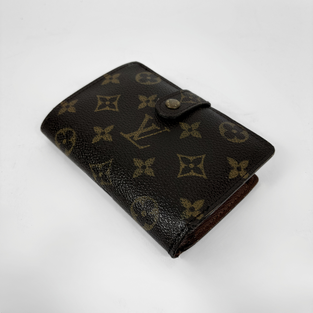 A Louis Vuitton monogram bifold wallet in dark brown coated canvas with tan monogram motifs, shown on a plain white background.