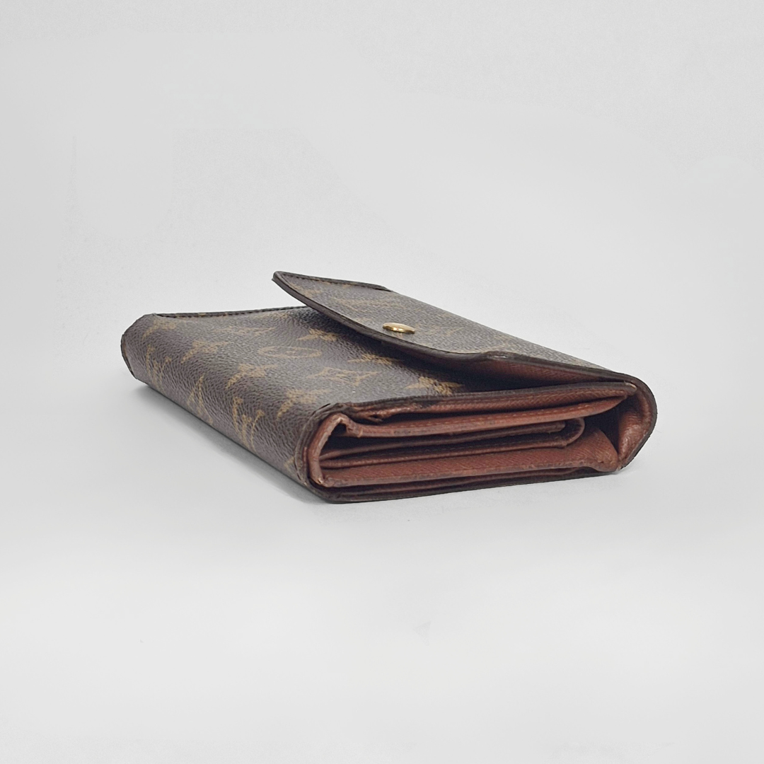 Folded brown wallet with monogram pattern on a light gray background