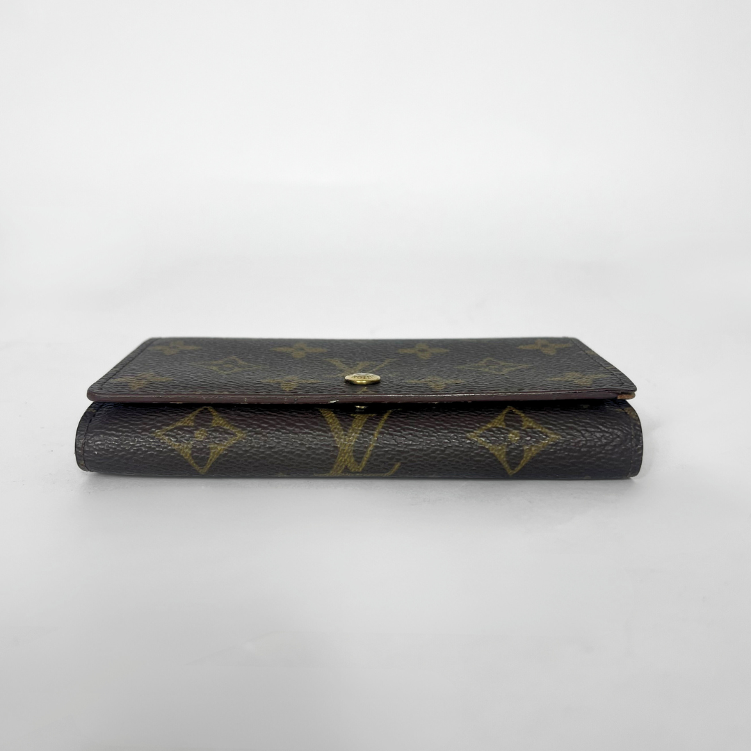 Louis Vuitton wallet with monogram pattern on a white background