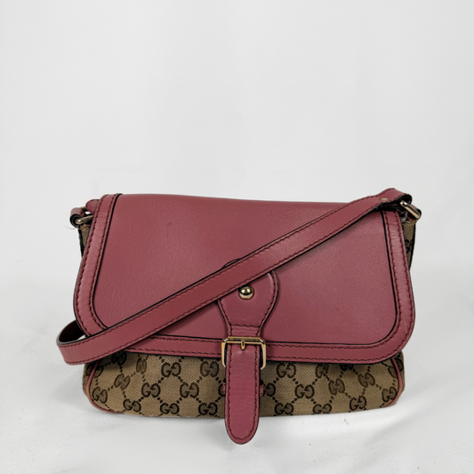 A vintage Gucci shoulder bag featuring a dusty rose leather flap and strap, combined with the classic brown and beige GG monogram canvas body, shown on a white background.