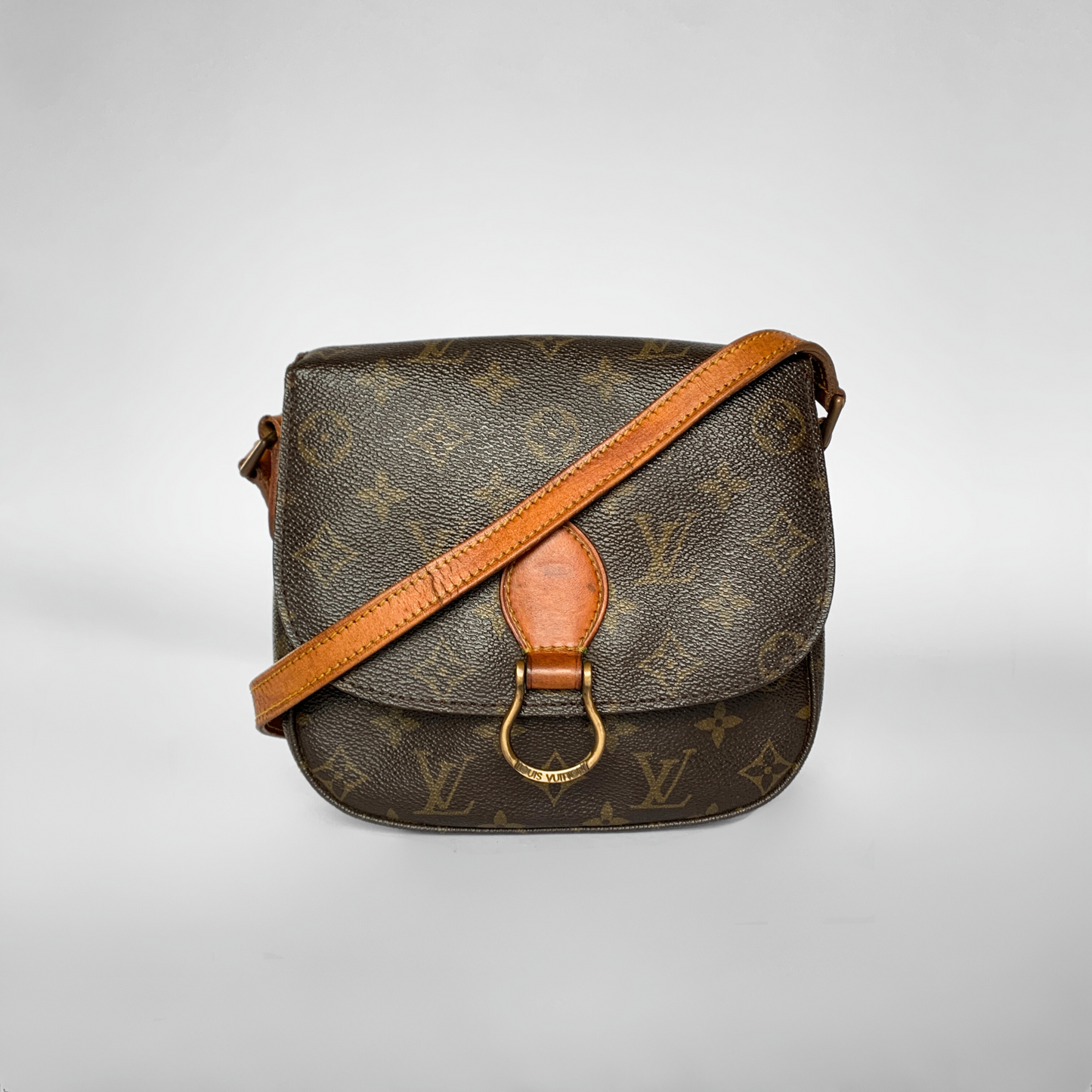 Brown monogram handbag with tan strap on a light gray background