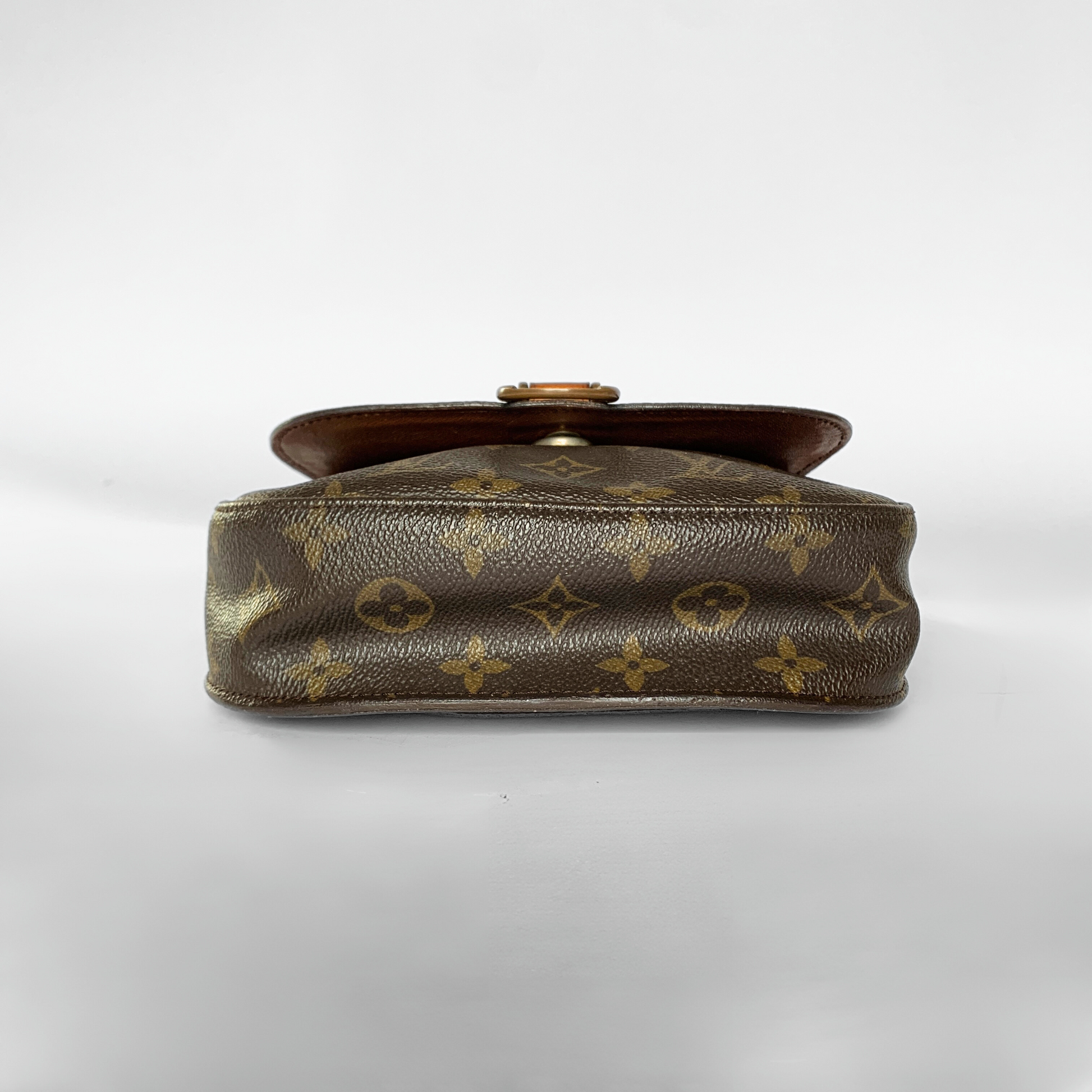 Brown leather handbag with gold monogram pattern on a white background