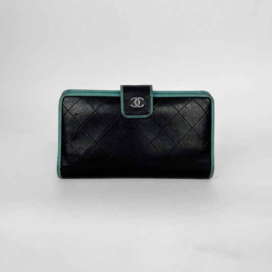 A black quilted leather clutch wallet with a silver-tone interlocking CC logo on the front flap, accented by a teal-green trim.