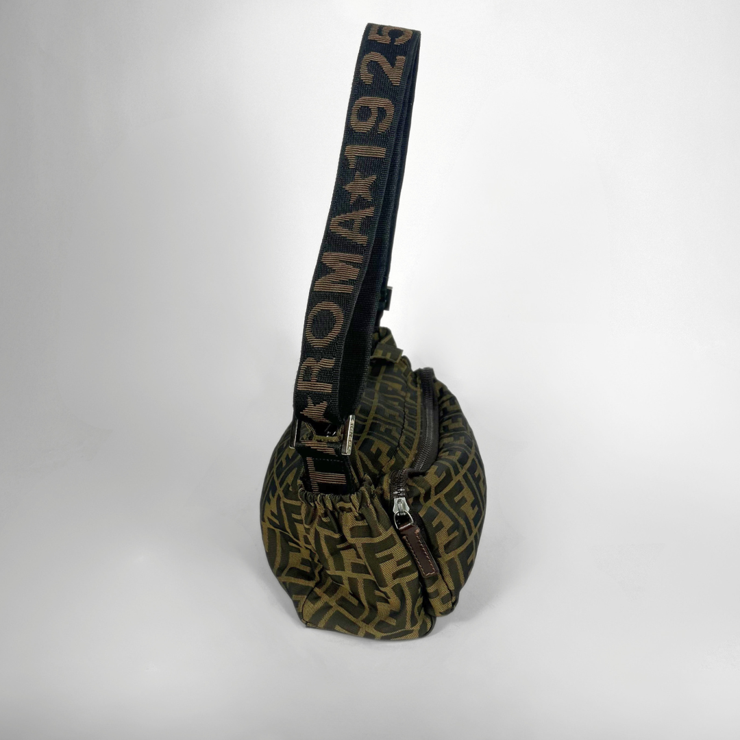 Green patterned bag with a black strap on a white background