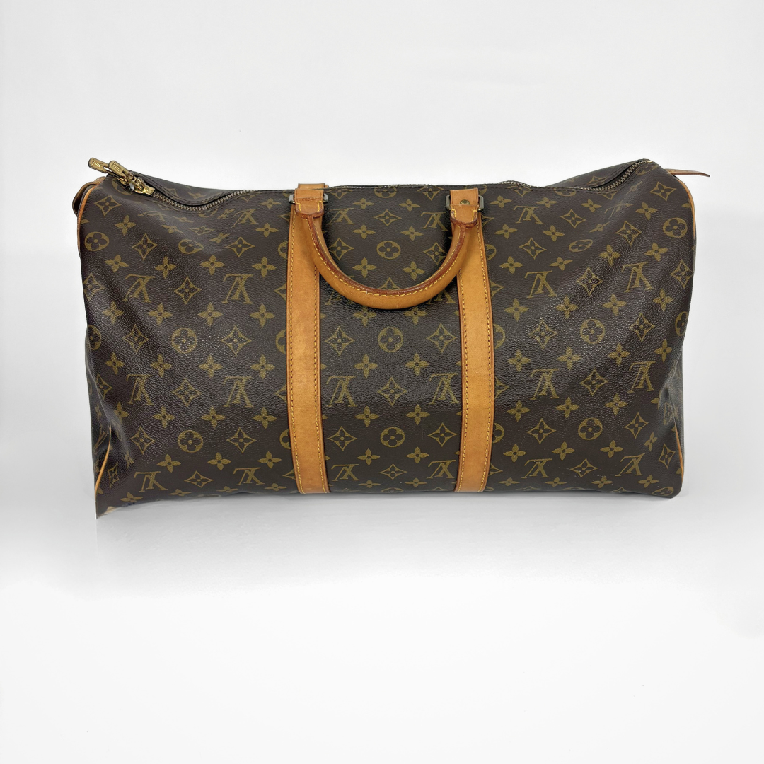 Louis Vuitton monogram travel bag with brown leather straps on a white background