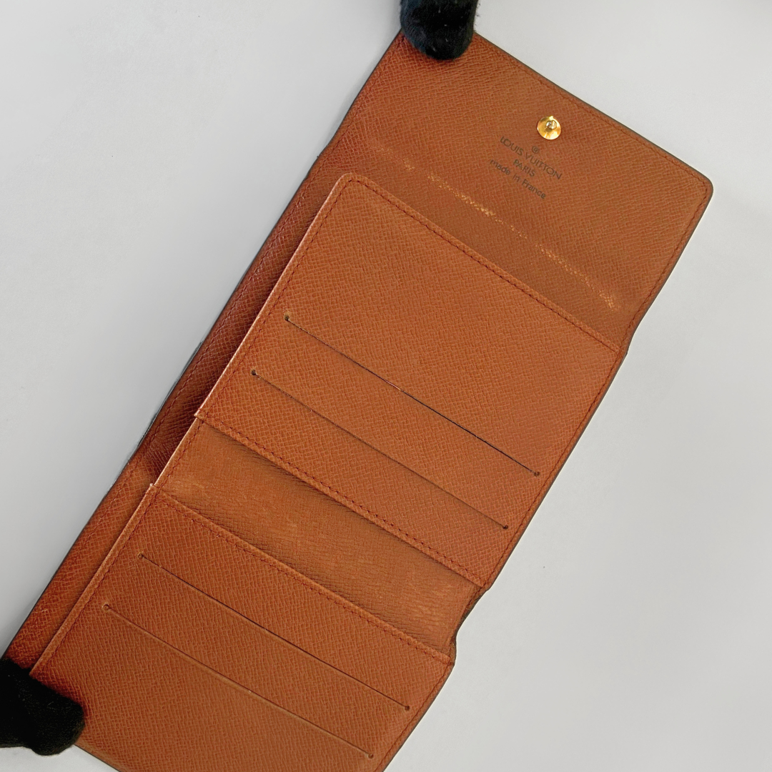Brown leather wallet with visible brand name on a light gray background