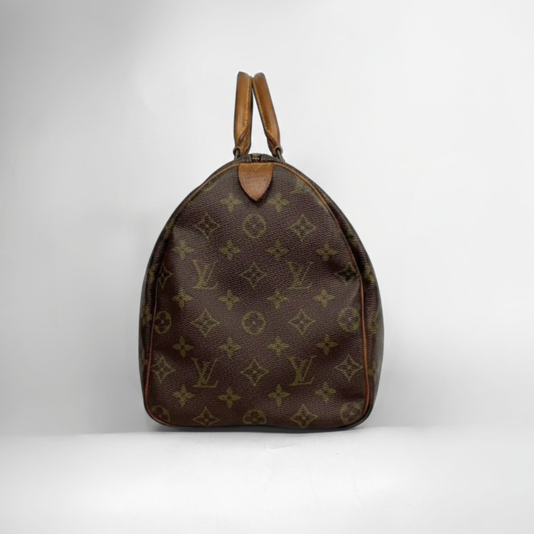 A Louis Vuitton monogram canvas duffel bag in dark brown with tan leather handles, photographed against a neutral light gray background.