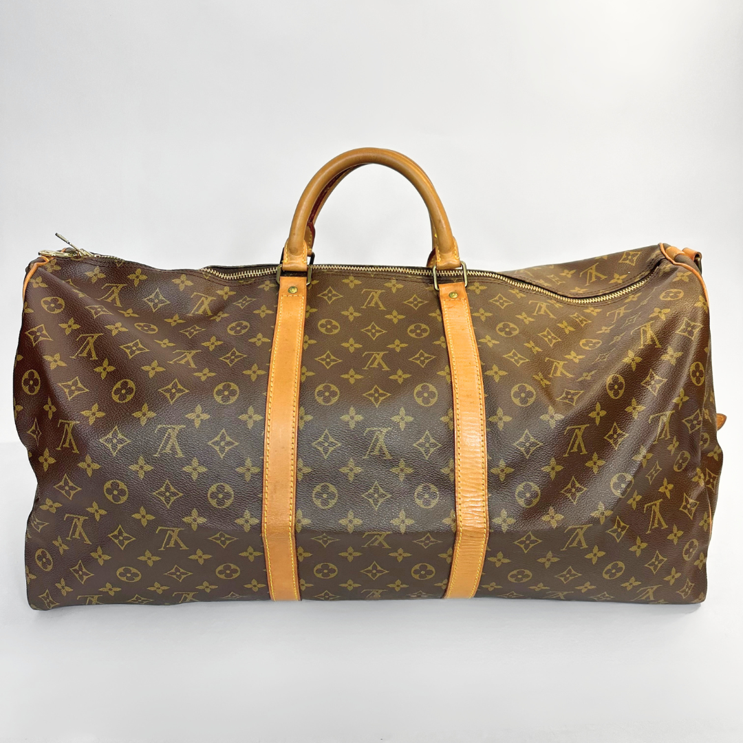Brown travel bag with tan handles and straps on a white background