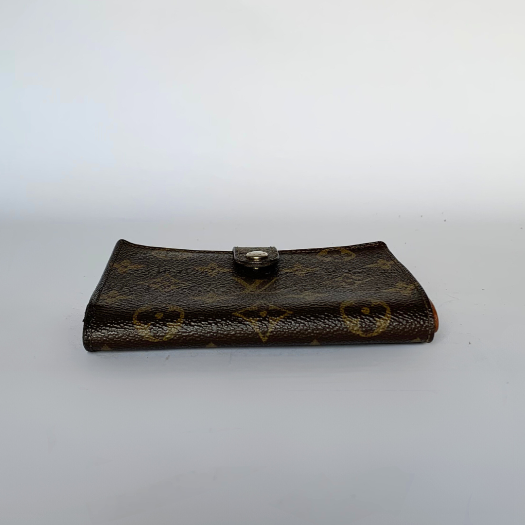 A Louis Vuitton monogram wallet in brown coated canvas with gold-tone hardware, photographed on a plain light gray background.