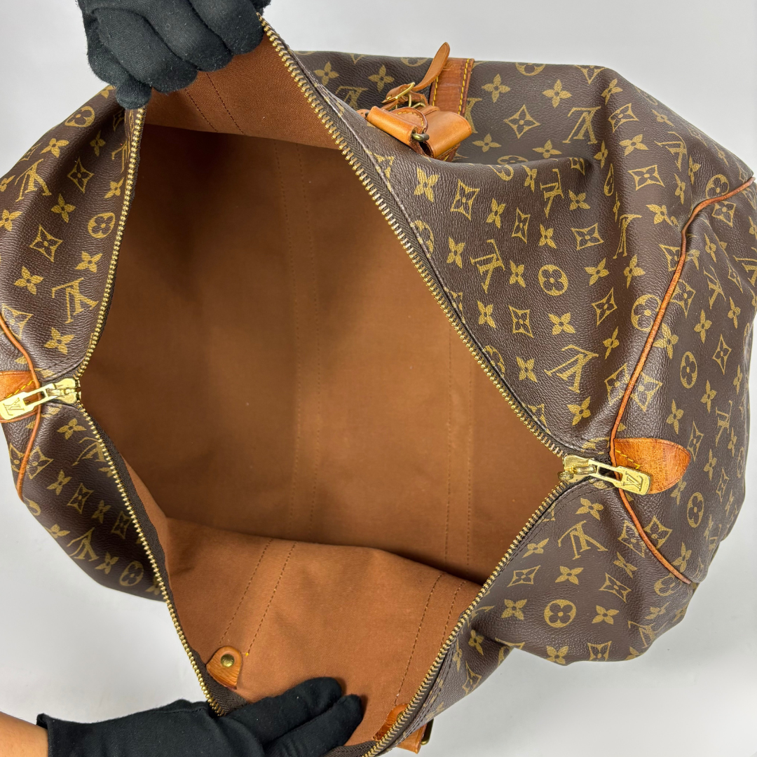 Brown Louis Vuitton travel bag with monogram pattern on a white background