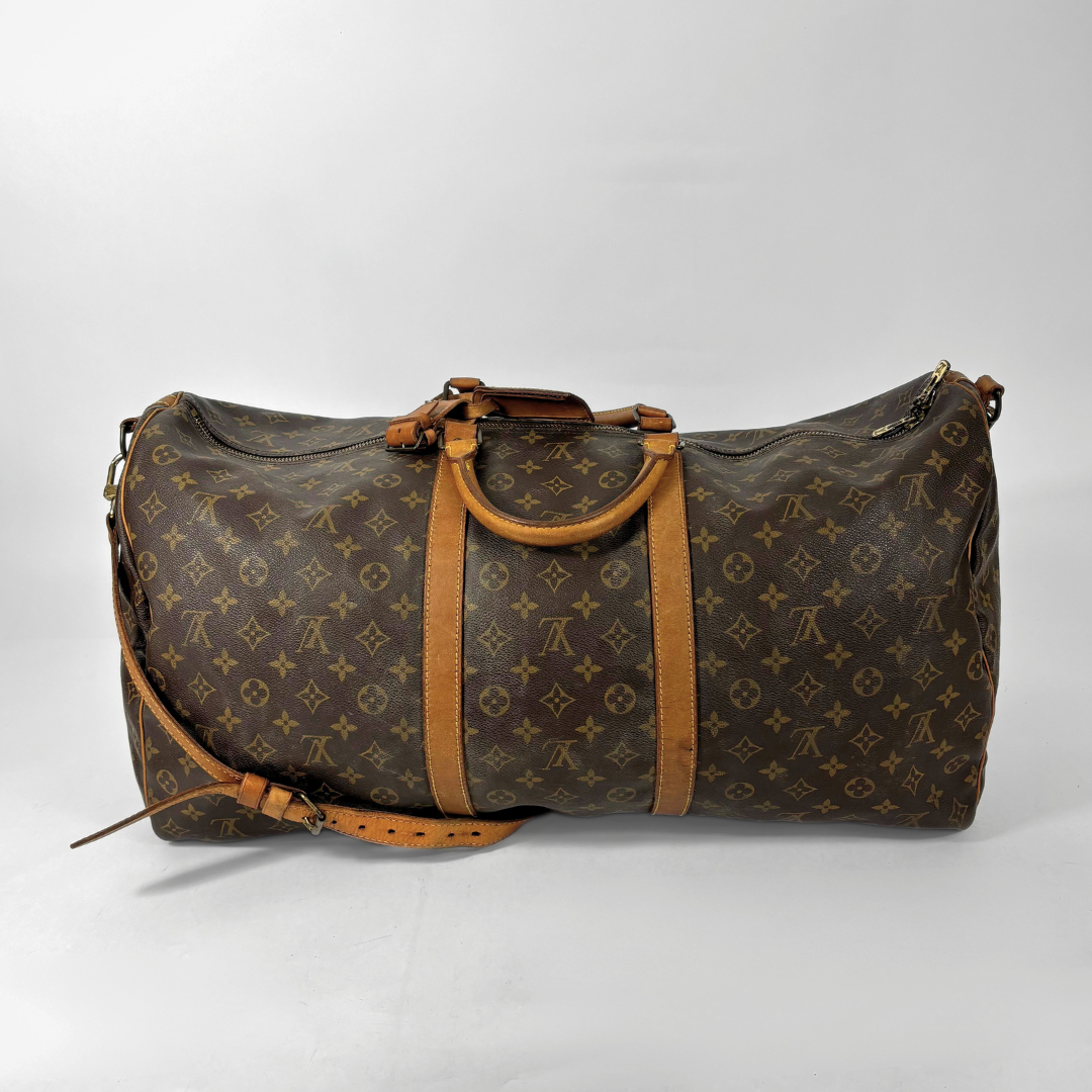 Brown duffel bag with tan leather straps on a light gray background