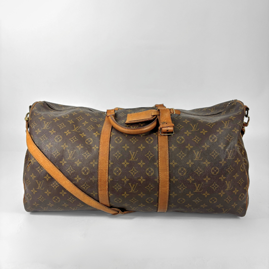 Brown Louis Vuitton travel bag with monogram pattern on a white background