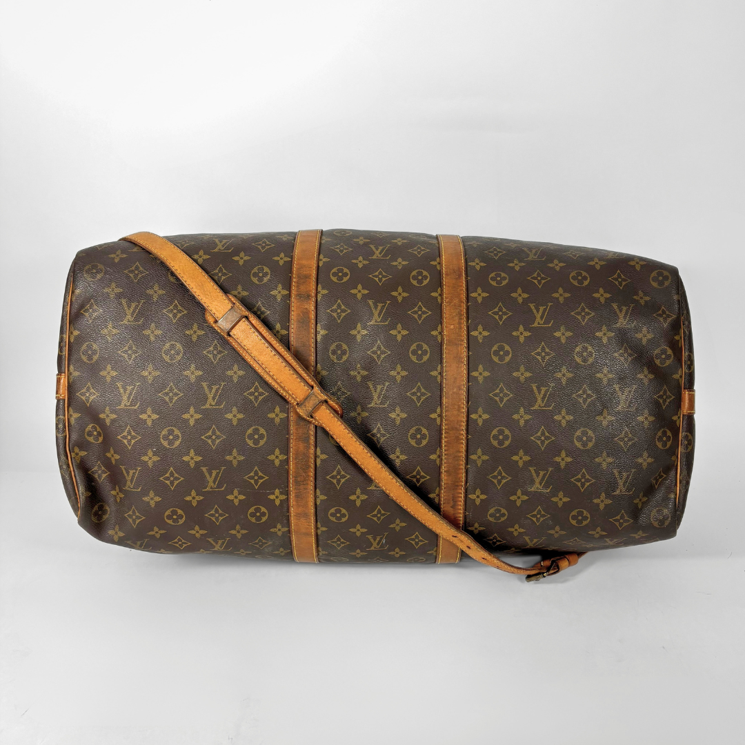 Brown Louis Vuitton travel bag with monogram pattern on a white background