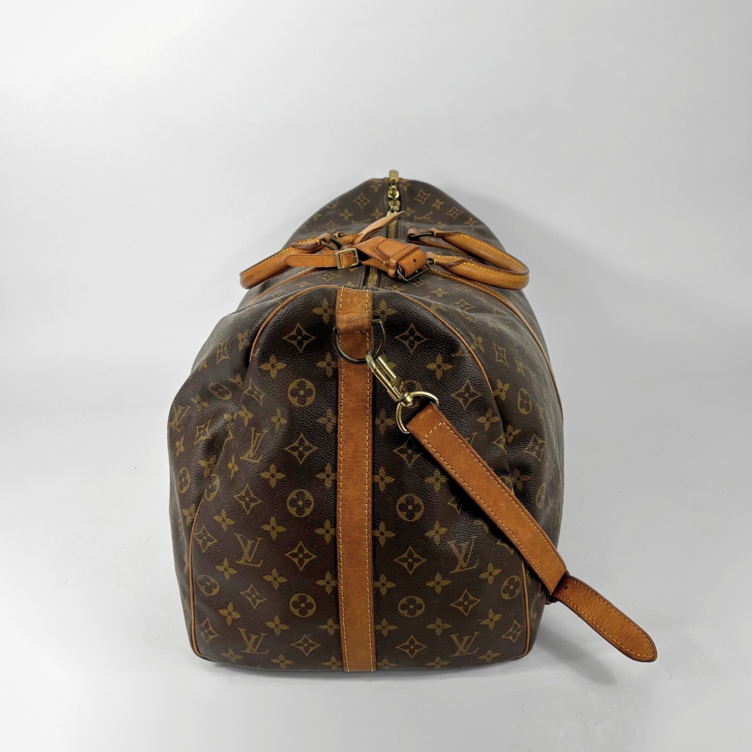 Brown Louis Vuitton travel bag with monogram pattern on a white background