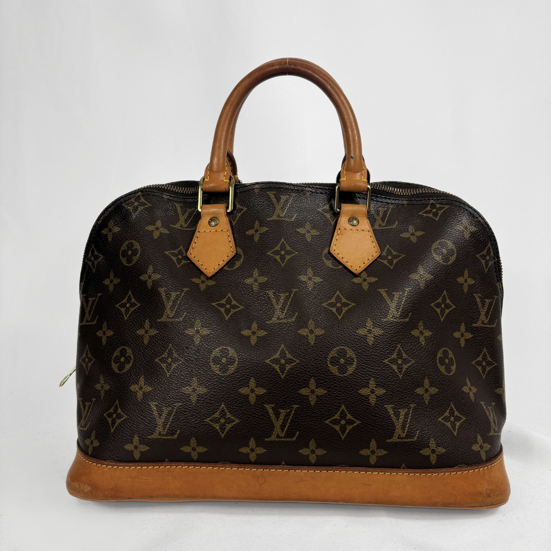Louis Vuitton monogram canvas handbag with tan leather handles and trim, photographed against a plain light background.