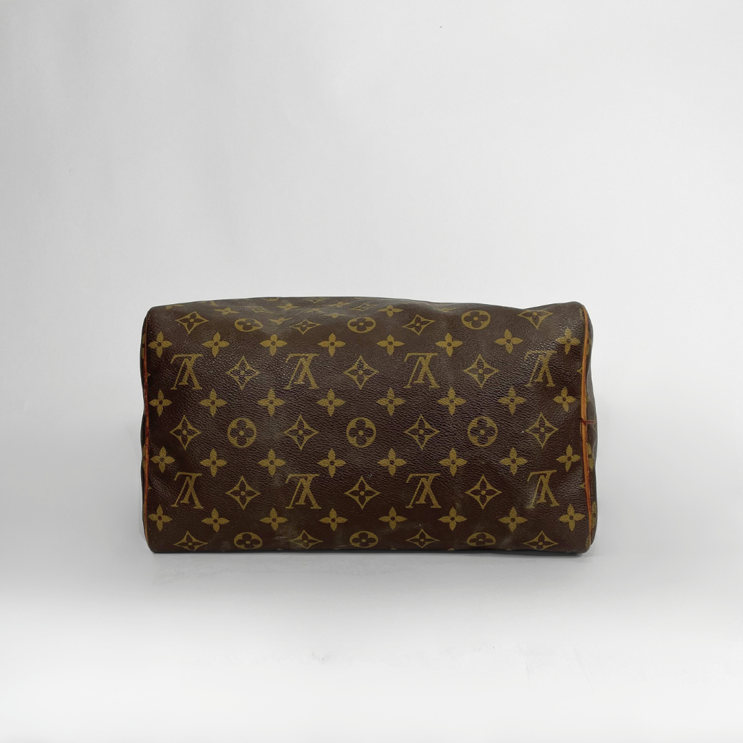 A Louis Vuitton monogram canvas shoulder bag in brown and tan, photographed against a neutral light gray background.