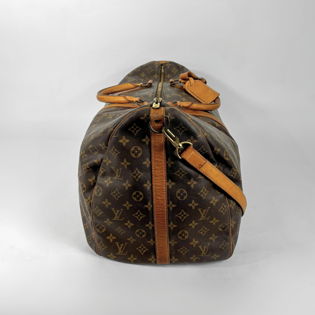 Brown Louis Vuitton travel bag with monogram pattern on a white background