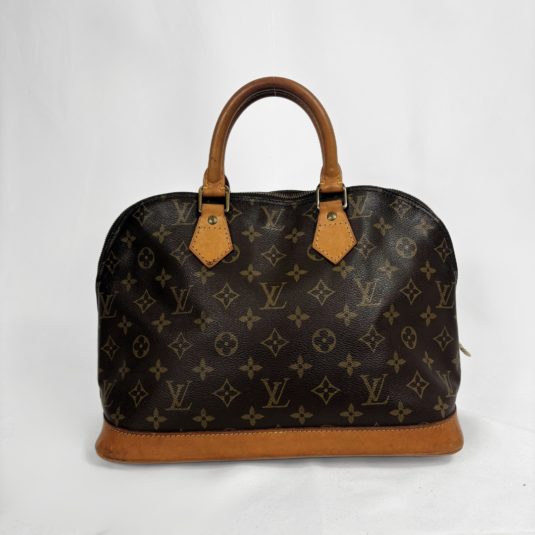 Louis Vuitton monogram canvas dome handbag with tan leather handles and base, photographed against a plain white background.