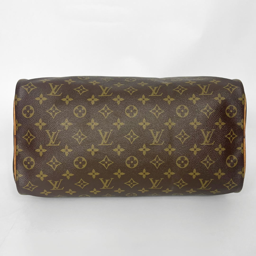 Brown leather bag with gold monogram pattern on a white background