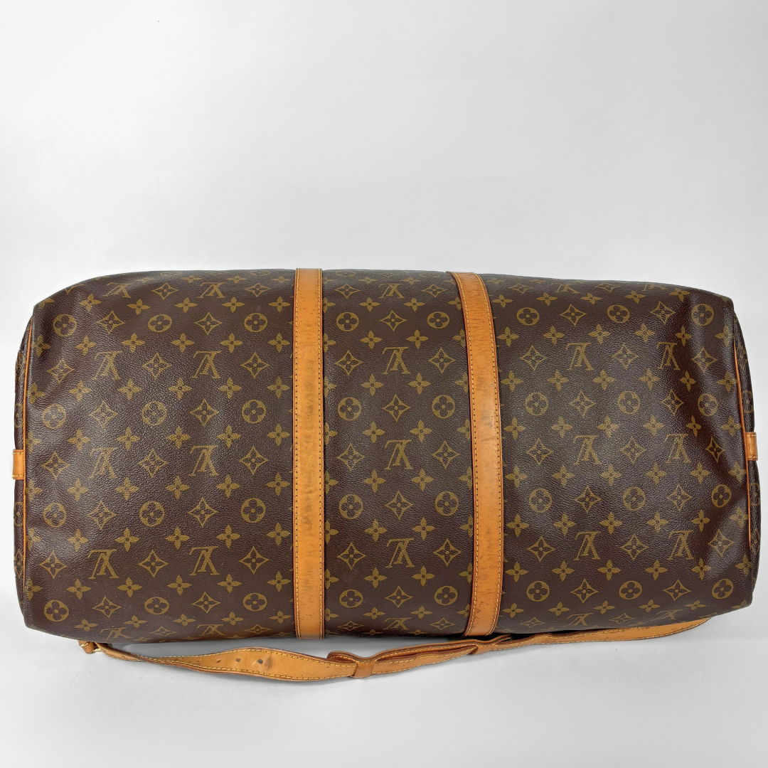 Brown Louis Vuitton travel bag with monogram pattern on a white background