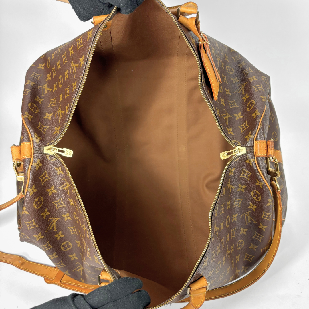 Brown Louis Vuitton travel bag with monogram pattern on a white background